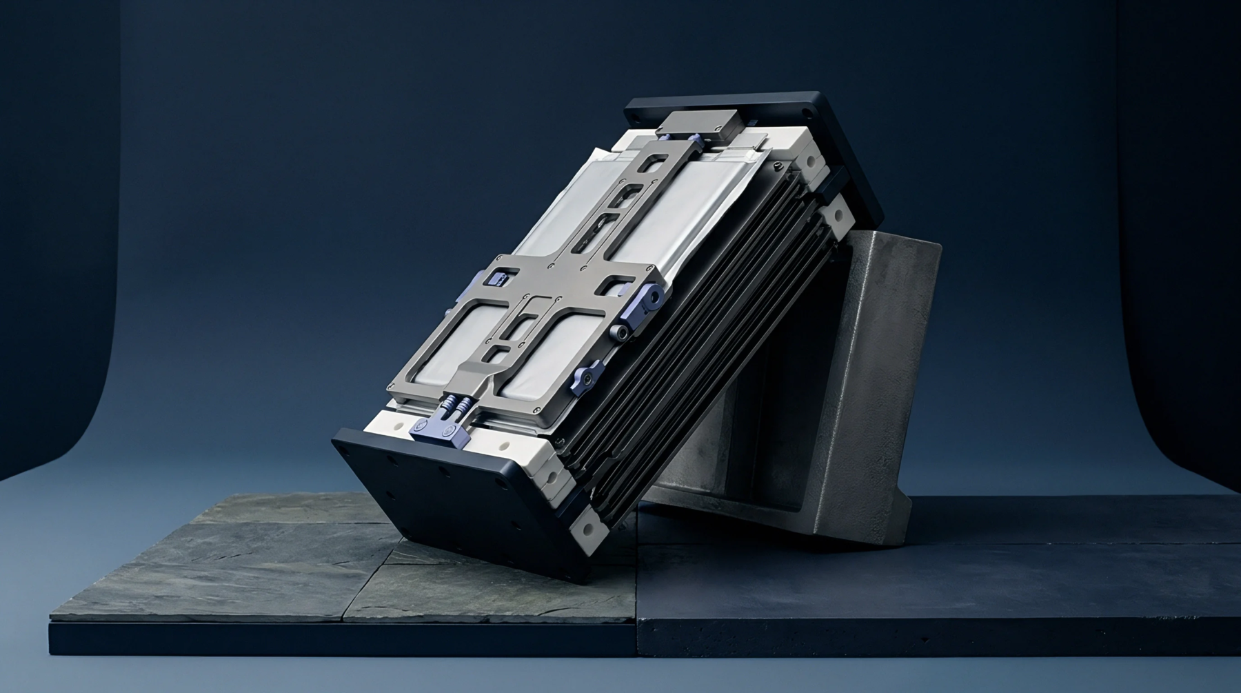 Stacked lithium ion pouch cells secured inside a precision mechanical compression fixture rest upon dark stone tiles under studio conditions.